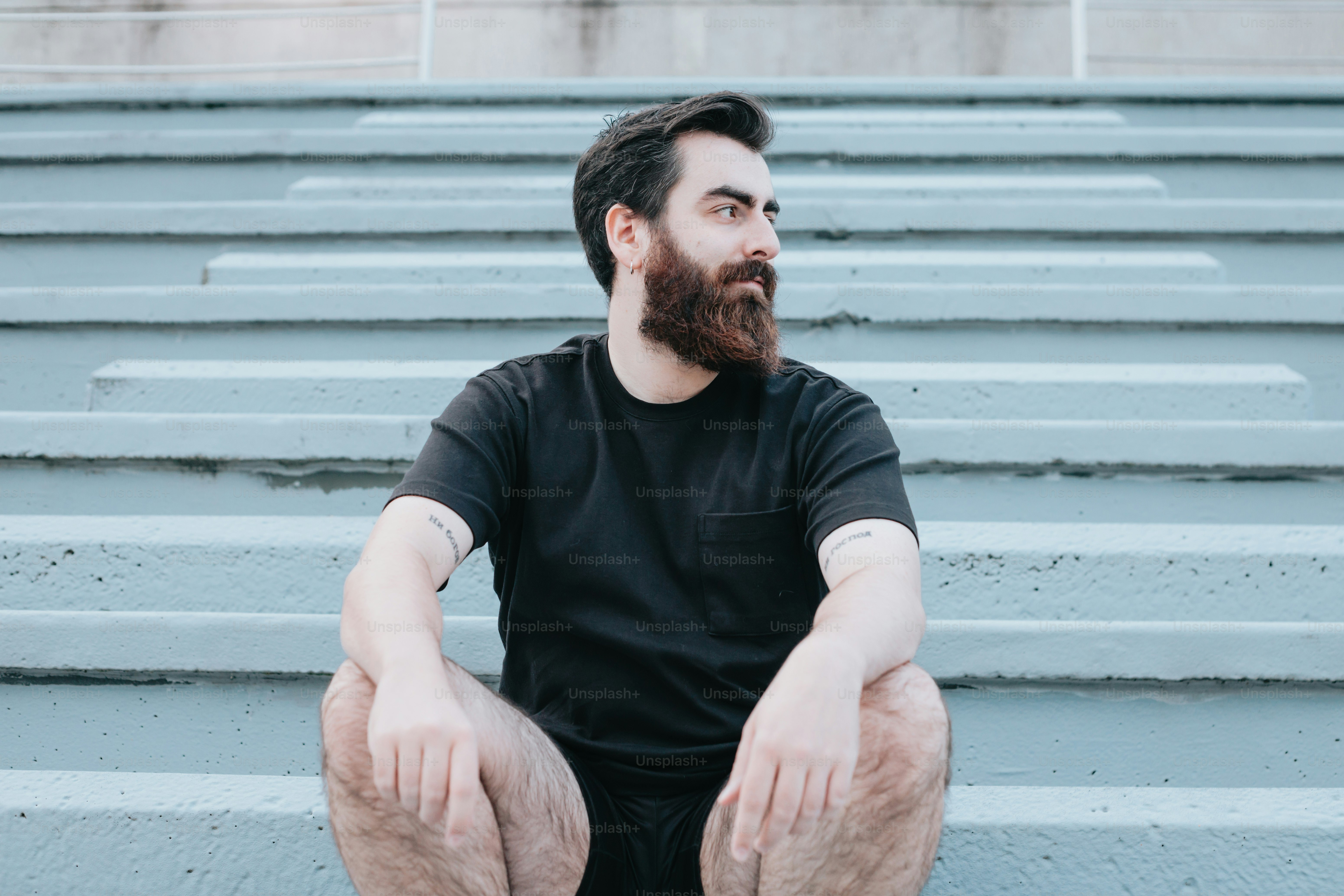 a man with a beard sitting on some steps