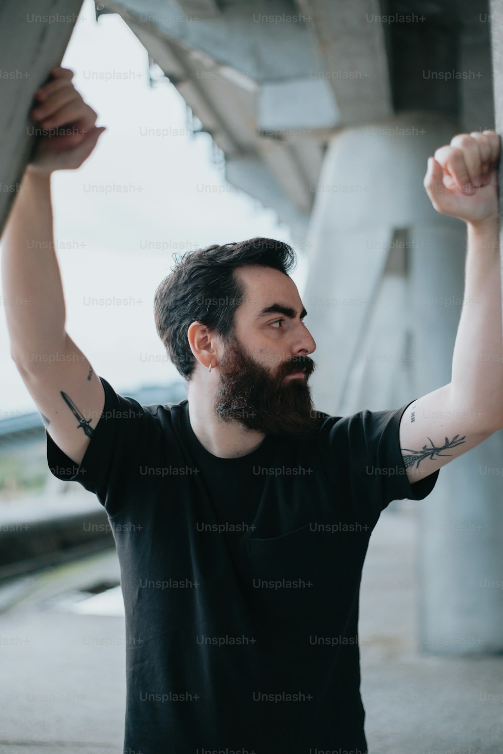Un uomo con la barba e tatuaggi sul braccio