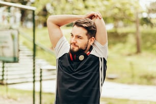 Portrait of young man doing stretching in public park