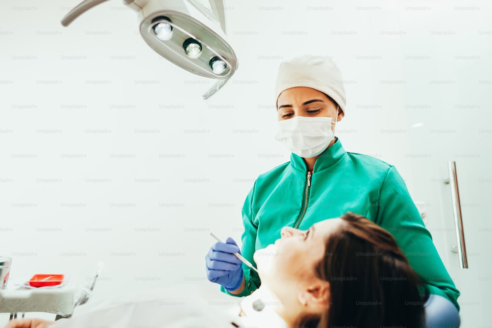 Donna dentista che esamina un paziente nella sua clinica