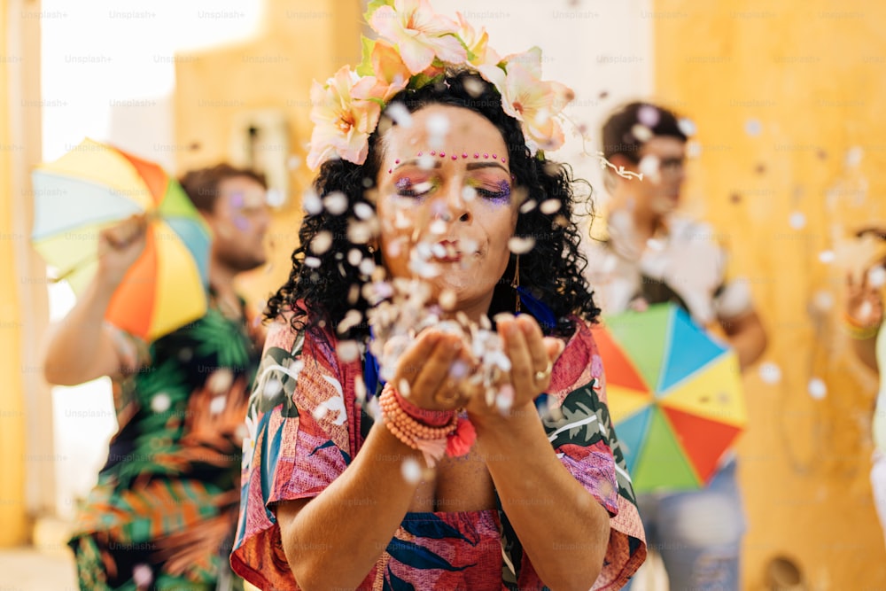 Carnevale brasiliano. Giovane donna che si gode la festa di carnevale soffiando coriandoli