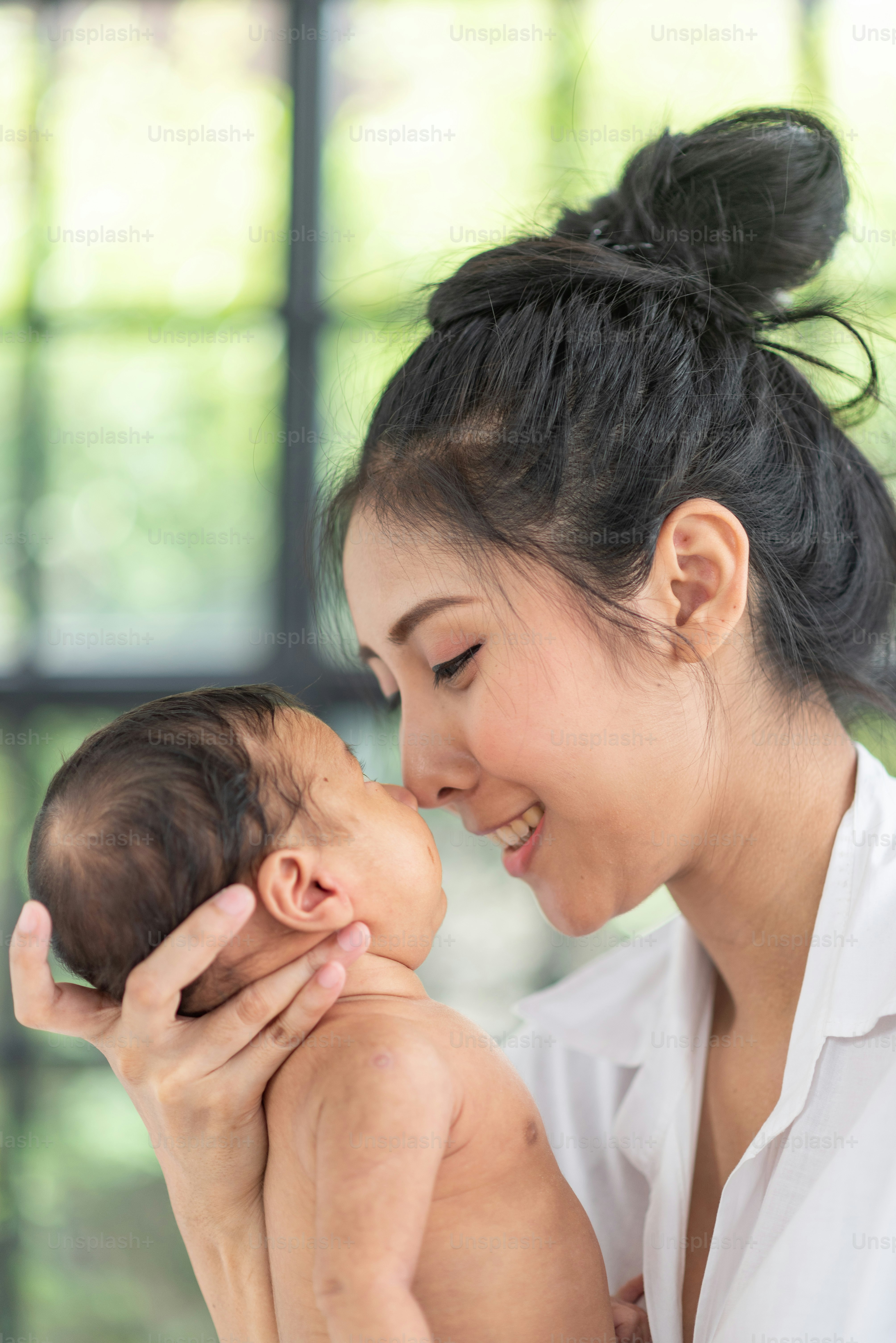A young mother carries a baby