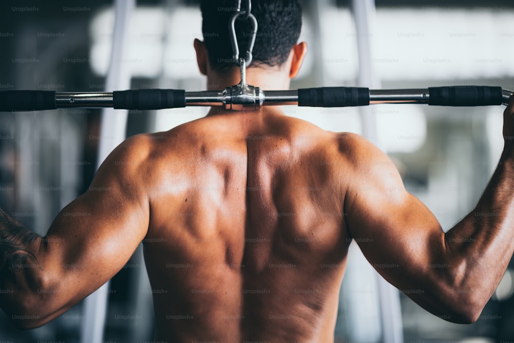 Muskulöser Bodybuilder-Typ zeigt sich im Fitnessstudio