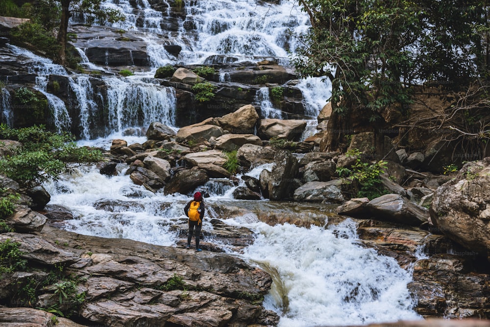 Reisen Sie entspannt, um die Wasserfälle der asiatischen Frau zu besuchen. Im Winter. Am Wasserfall Mae Ya Chiangmai. Reisen Sie in die Natur. Sommer