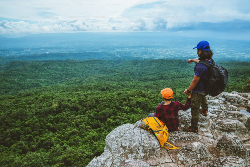 Lover woman and men asians travel relax in the holiday. View mountain nature on the cliffs.