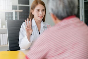 smart and attractive asian woman doctor explain and discuss with old asian man for consult clinic background health concept