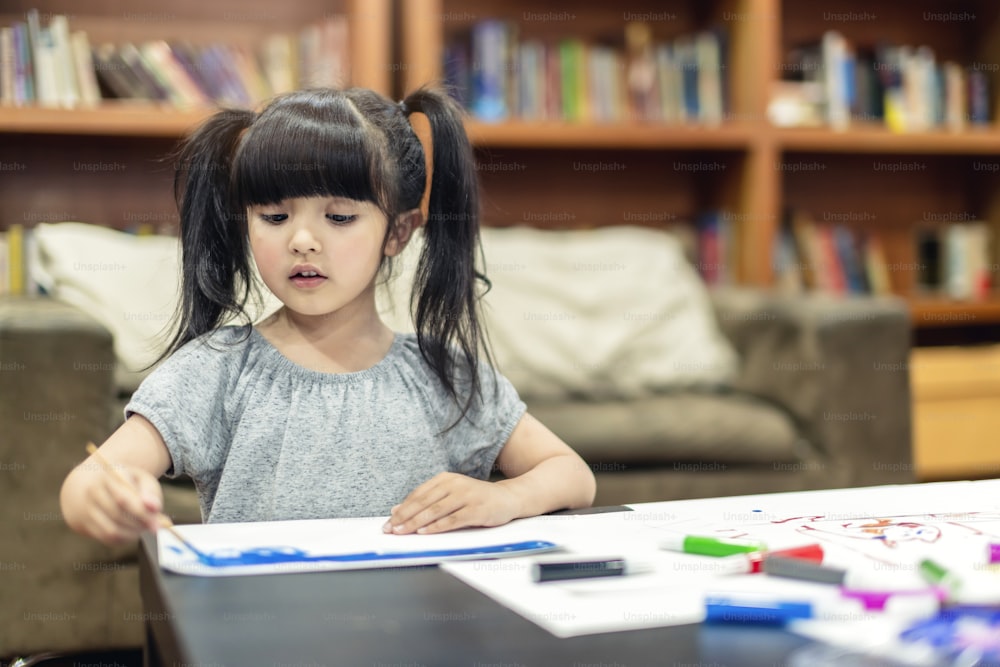 niña caucásica bonita niña disfruta pintando crayón color arte en papel hogar concepto familiar