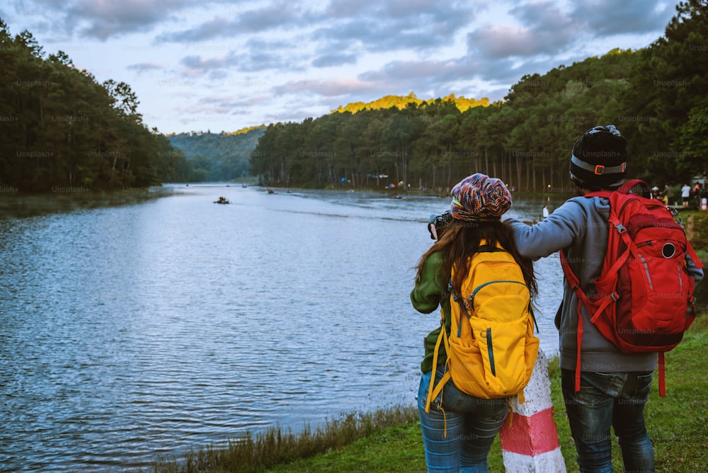 Happy couples with natural tourism, standing admire the beautiful landscape the Pang Ung lake, Mae Hong Son in Thailand.