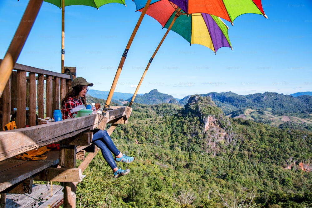 The girl sitting eating noodle in the rural village hanging legs style for viewpoint on the mountain,The local attractions of Mae Hong Son province Thailand.