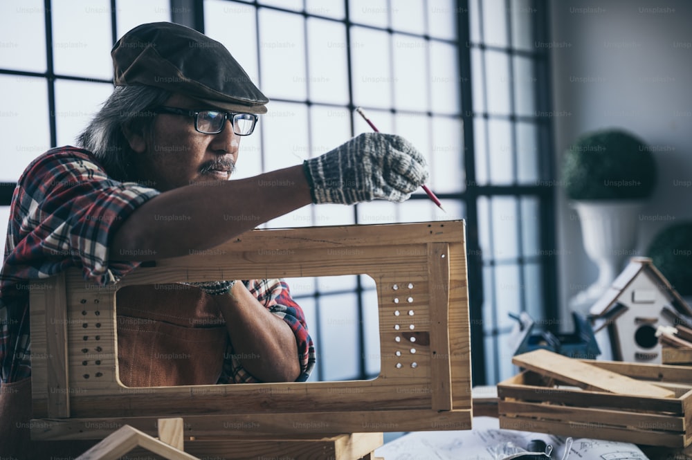 Um carpinteiro está projetando e trabalhando em madeira feita à mão.