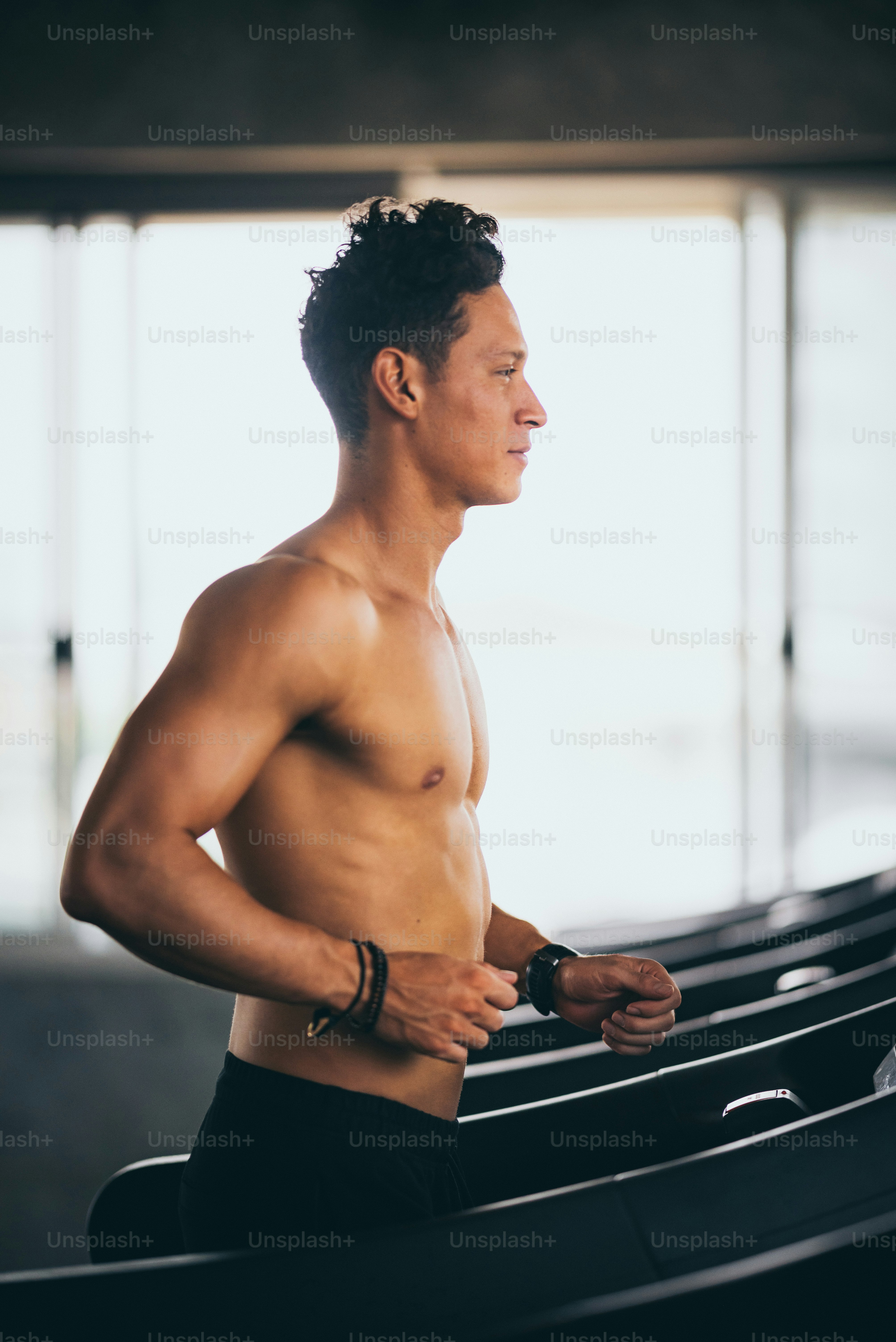 handsome man running on treadmill in fitness gym
