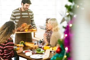 Happy American family communicating while having Thanksgiving lunch in dining room festive ideas concept