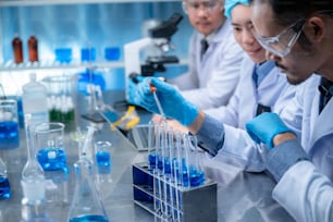 Science et médecine, scientifique analysant et déposant un échantillon dans une verrerie, expériences contenant un liquide chimique en laboratoire sur verrerie, structure de l’ADN, innovation et technologie.