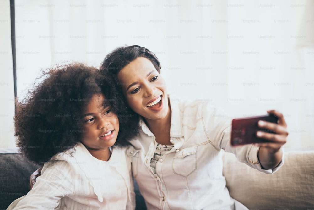 Mother and daughter are taking selfies with their smartphone
