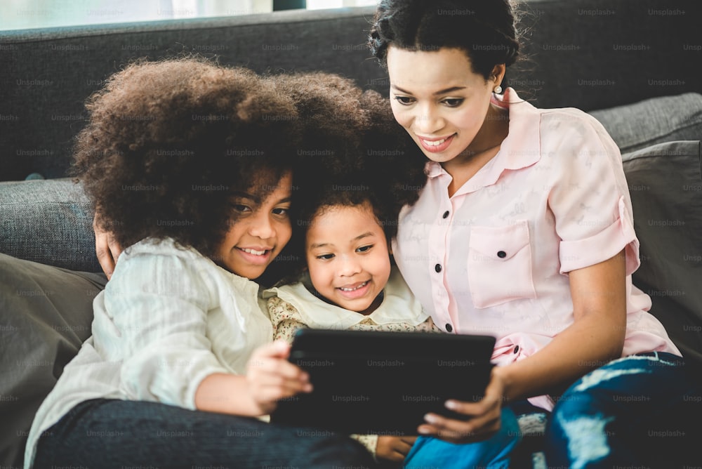 Happy American African family watching tablet on bed at home, The concept of families of all ages is enjoying the activities in the house.