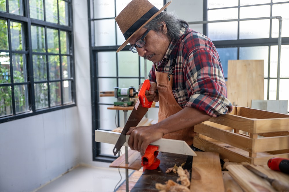 Uomo falegname professionista che lavora con la costruzione di utensili per l'industria della lavorazione del legno, officina della persona dell'artigiano con legname e attrezzature per la lavorazione del legno