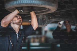 mechanic car service working in garage, workshop to check and maintenance repair automobile, suspension industry technology, vehicle inspection fix man technician work