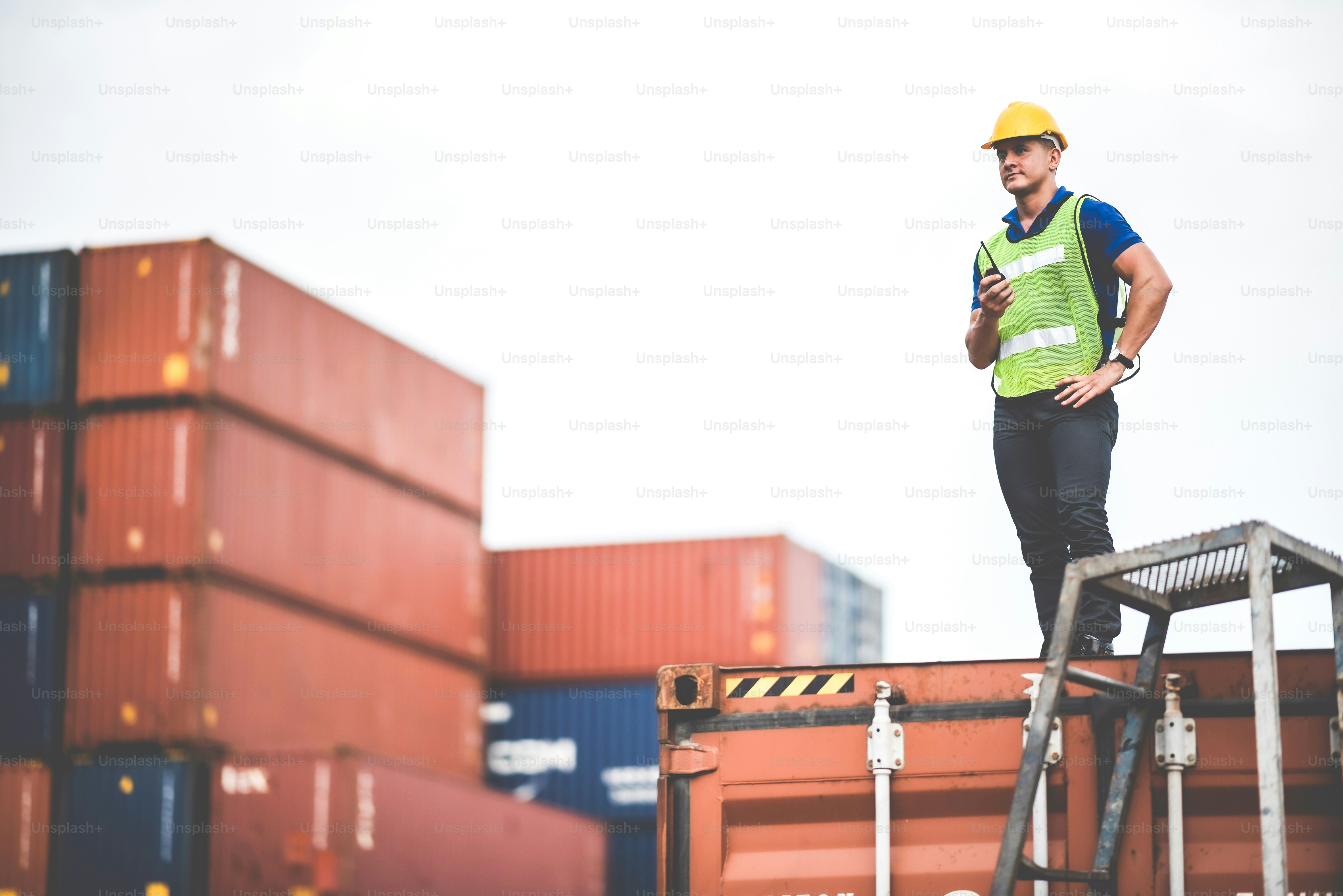 manajer pekerja mandor bekerja di luar ruangan, situs kontainer kargo, rencana kontrol bekerja, bekerja dengan peralatan keselamatan, rompi keselamatan helm, konsep walkie talkie teknologi.menuding jari