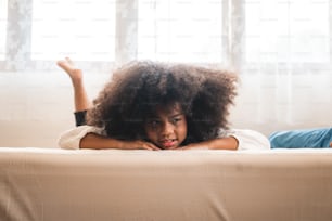 ragazzo africano primo piano sul suo viso protrait, capelli ricci afro, bellissimo figlio, sfondo bianco a casa, giocando sul letto, concetto di famiglia, ragazzo sorridente, bambino carino e adorabile.