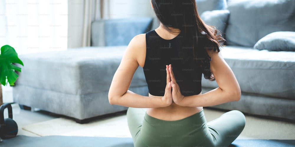 Young woman doing online yoga at home. Online fitness, home workout. - a  Royalty Free Stock Photo from Photocase
