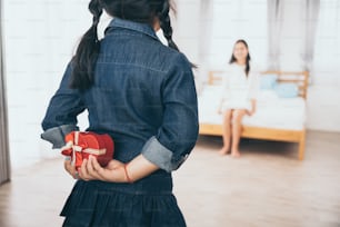 daughter give mother a present box on mother's day at home, asian kid give mom a gift to show her love