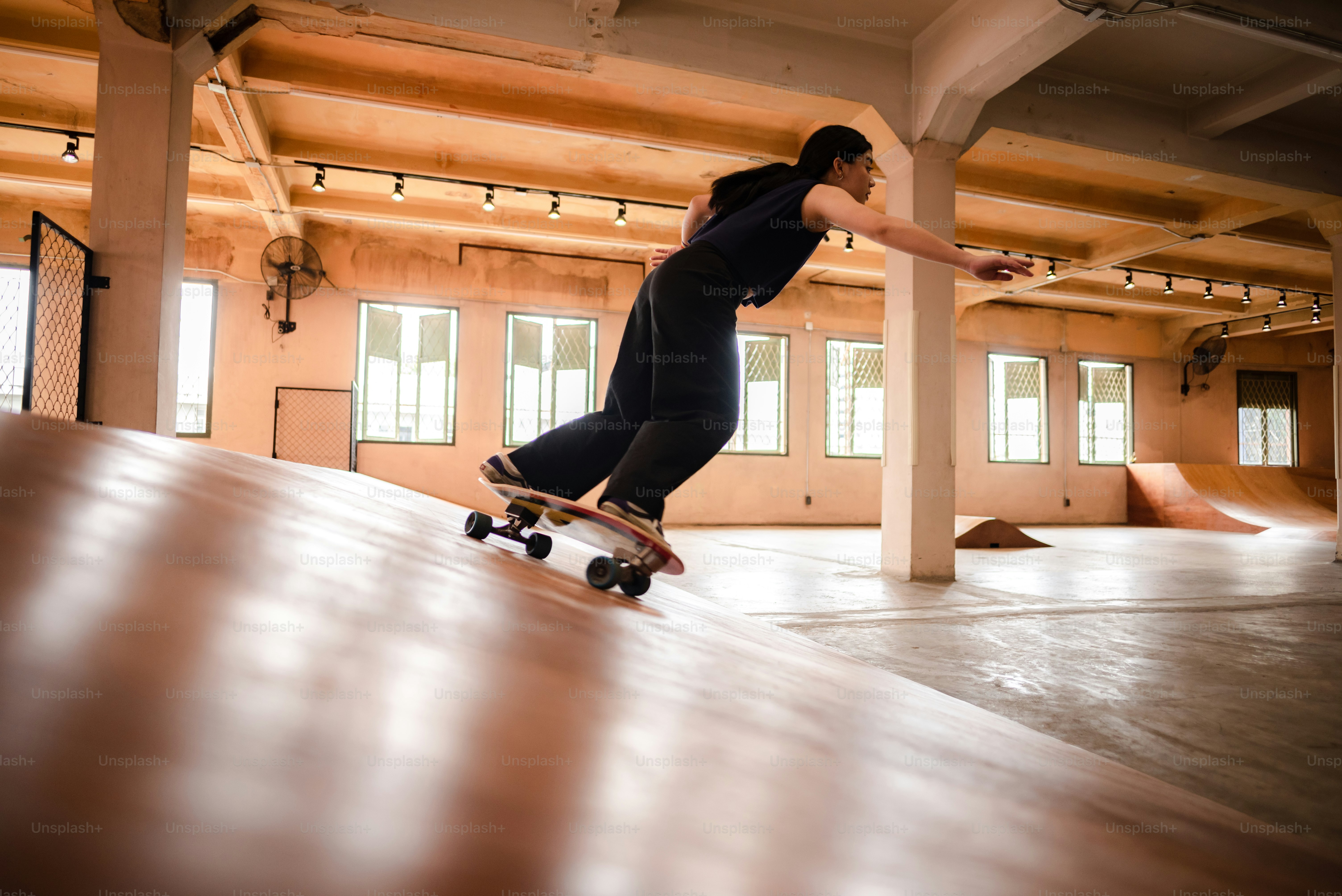skater woman person playing skateboard in sport gym, young Asian woman are happy and fun with skateboarding lifestyle in city, teenage hipster female trendy fashion