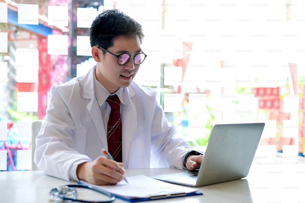 Young male doctor asian working with laptop in the office