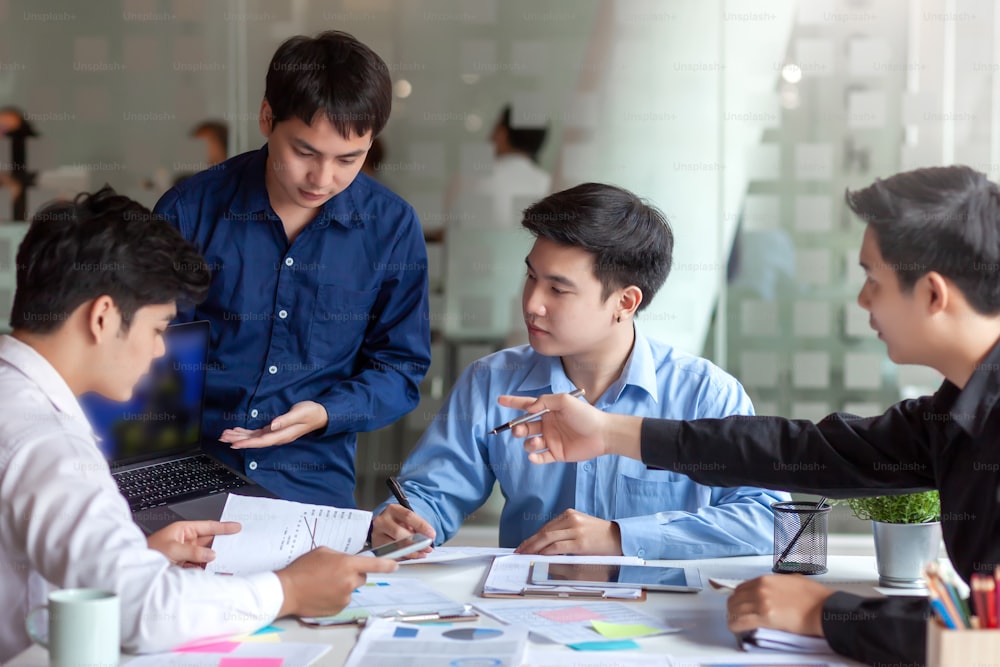 Encontro de jovens empresários asiáticos comprometidos com o trabalho. Equipe de negócios criativa sentada trabalhando junta no escritório.