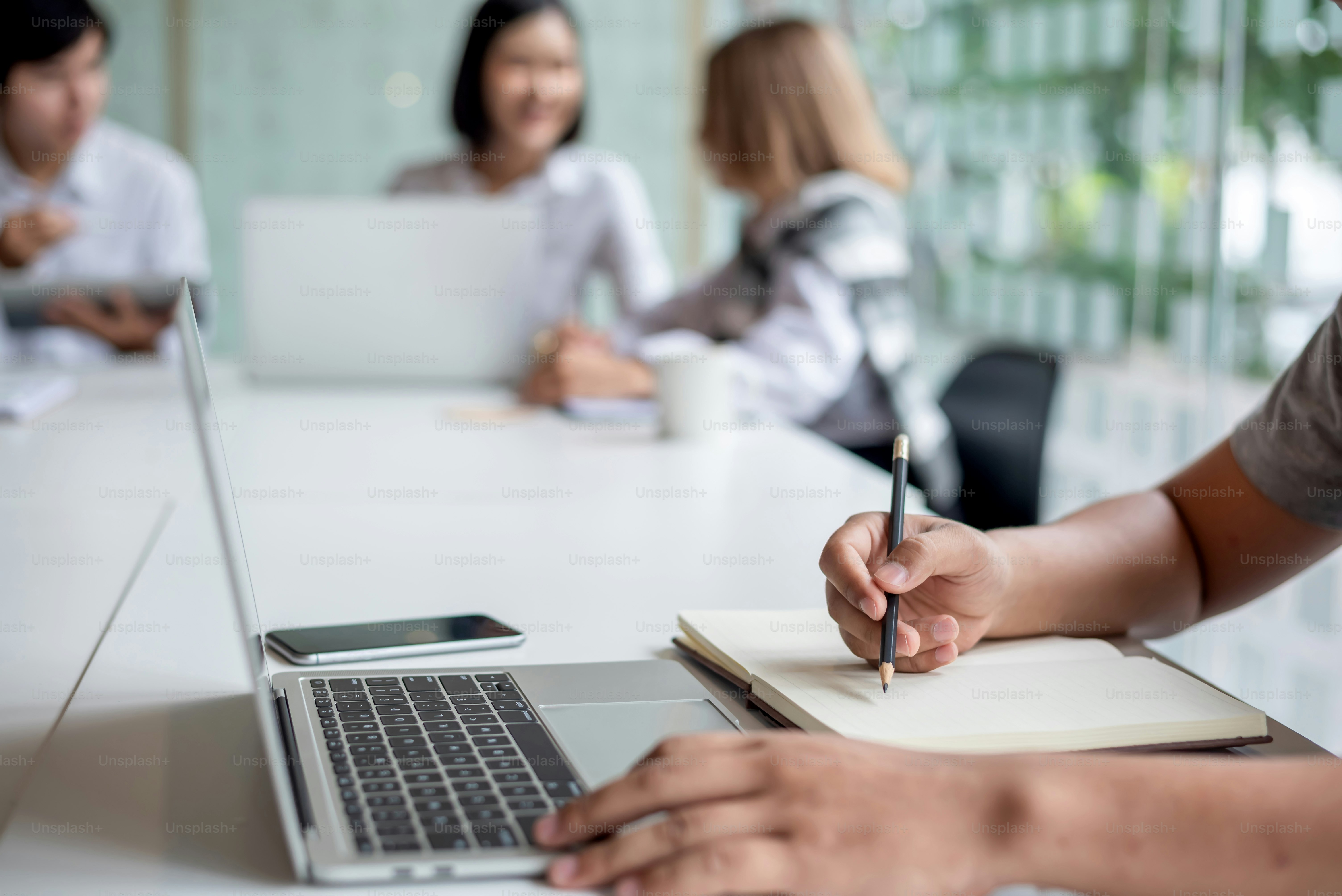 Gruppo di giovani uomini d'affari asiatici condividono insieme opinioni e propongono nuove idee di marketing e di business all'incontro.