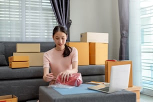 Jeune femme entrepreneure asiatique démarrer une petite entreprise travaillant à l’ordinateur à domicile. Activité de vente en ligne.