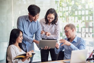 Group of young asian modern people in smart casual wear talking and smiling during the meeting in office.