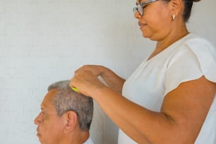 A mature woman combing her husband's hair
