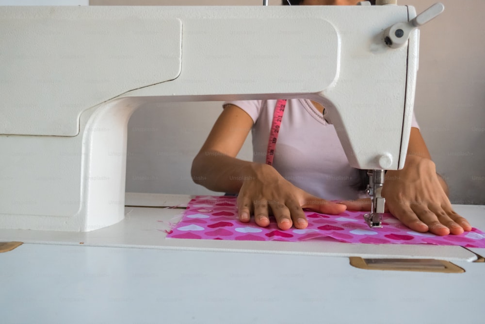 Una joven que usa una máquina de coser en la sastrería.