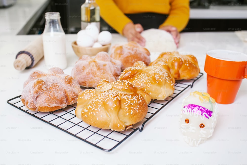 Mexican woman baking Pan de Muerto traditional bread from Mexico in Halloween
