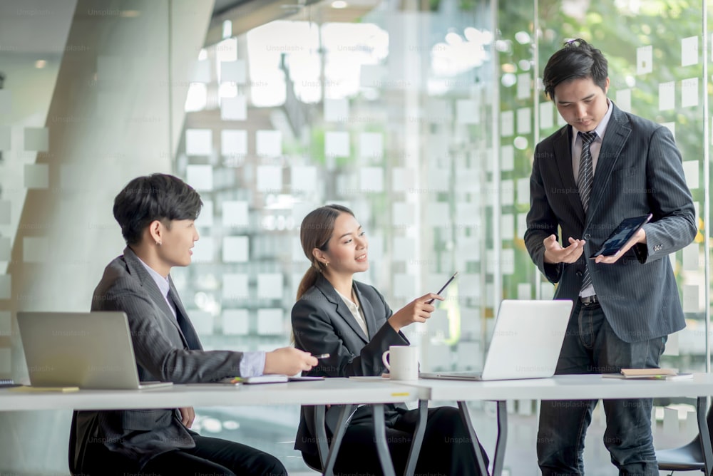 Group of modern business people are talking and smiling at the meeting. Asian business groups discussed investment and business planning at the meeting.