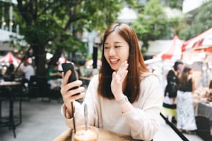 현대 가제트 기술을 가진 젊은 성인 비즈니스 아시아 여성. 당일 야외 카페에서 인터넷 회의를 위해 태블릿을 사용합니다. 주말에는 도시 독신 캐주얼 라이프스타일. 방콕, 태국
