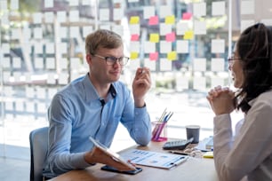 Modern business people discussing work in office and using a digital tablet together while working.