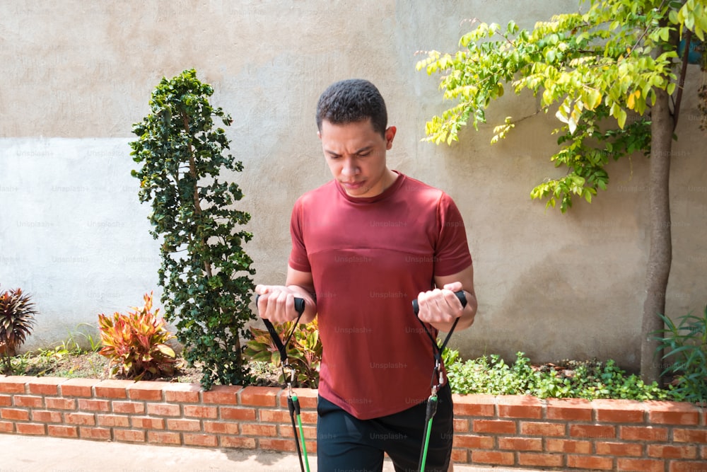 The man working out with the stretching band. Muscular athlete working out with a rubber band. Man working out with a rubber band. Fit, fitness, exercise, training and healthy lifestyle