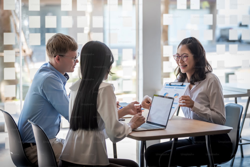 Business people gather to analyze marketing and investment information and using pen pointing to financial data chart at meeting.