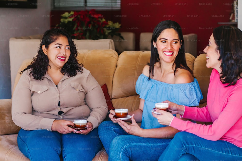 Latin women friends hanging out and drinking coffee in home in Mexico city