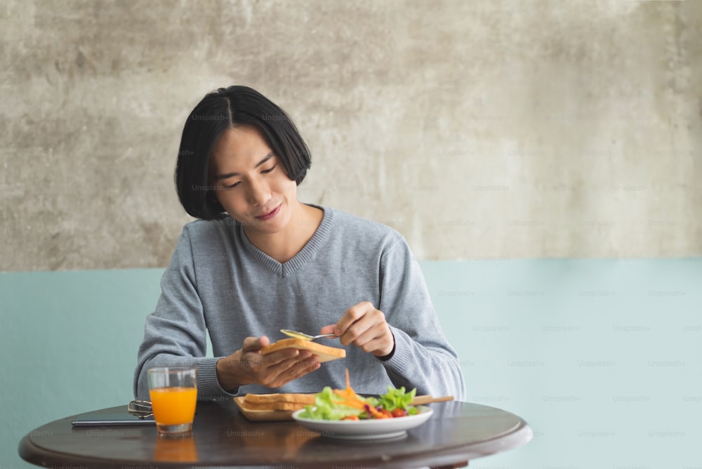 Homem asiático desfrutando com salada em suas férias no hotel. Alimentação saudável, Cuidados de saúde.