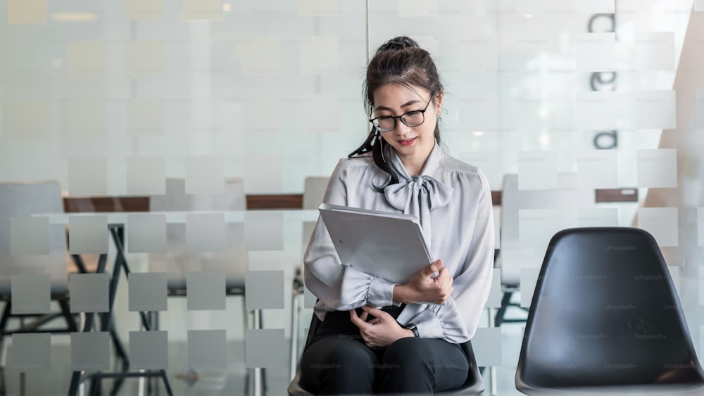 Asian woman holding the tablet waiting for job interview.