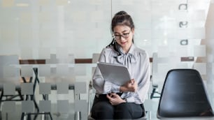 Asian woman holding the tablet waiting for job interview.