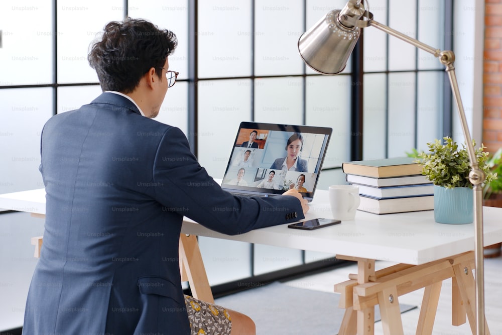 Joven hombre de negocios asiático divertido que usa ropa interior bóxer trabajo en casa y reunión de videoconferencia virtual con colegas gente de negocios, trabajo en línea, videollamada en la oficina en casa