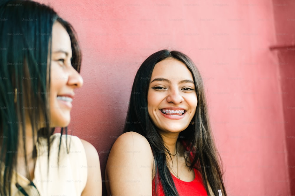 portrait of two cheerful young women smiling while talking. friendship and dental health concept.