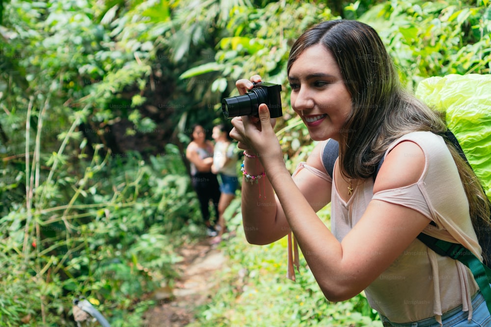Beautiful woman taking photos in a tropical forest in Colombia.