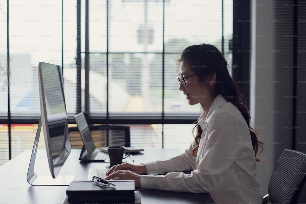 Young asian businesswoman typing keyboard on laptop computer in the office.