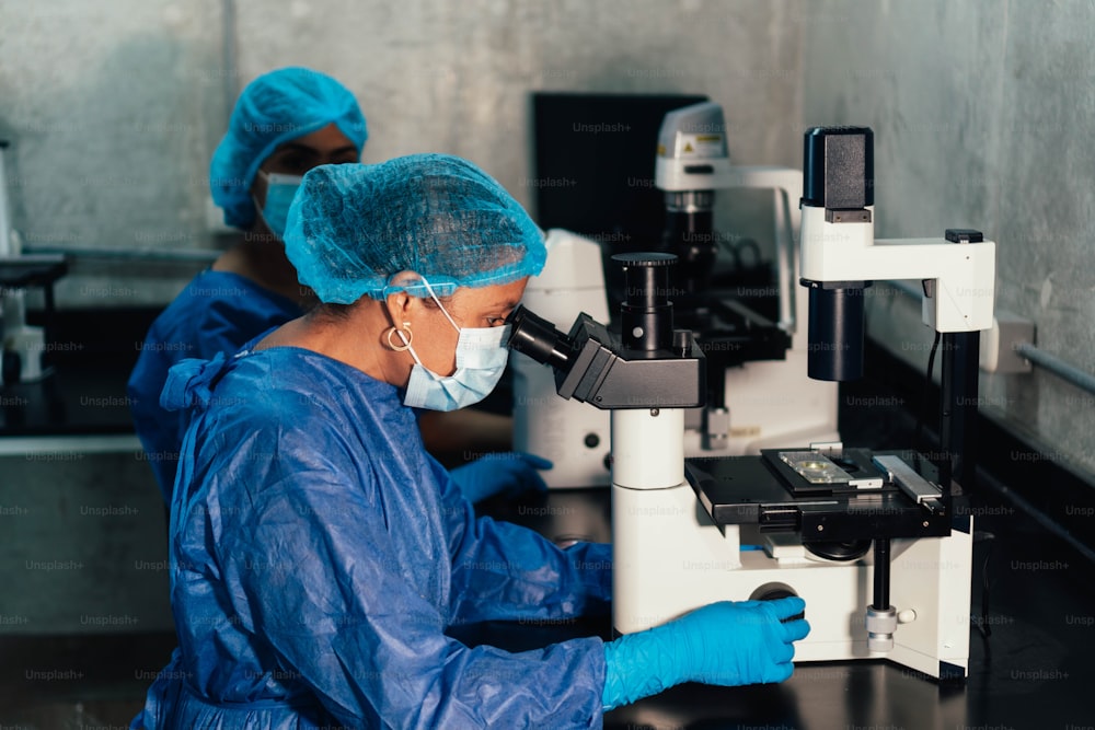 Biólogos olhando através de um microscópio em um laboratório. Biólogo fazendo algumas pesquisas.