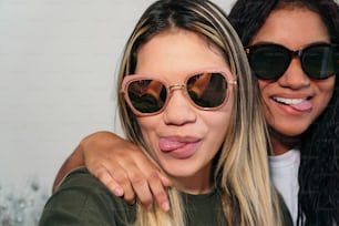 Des amis multiethniques avec des lunettes de soleil prenant un selfie