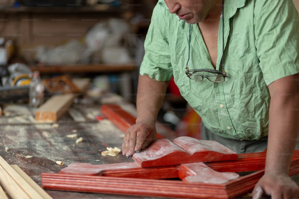 Mexican carpenter sanding a wood cross